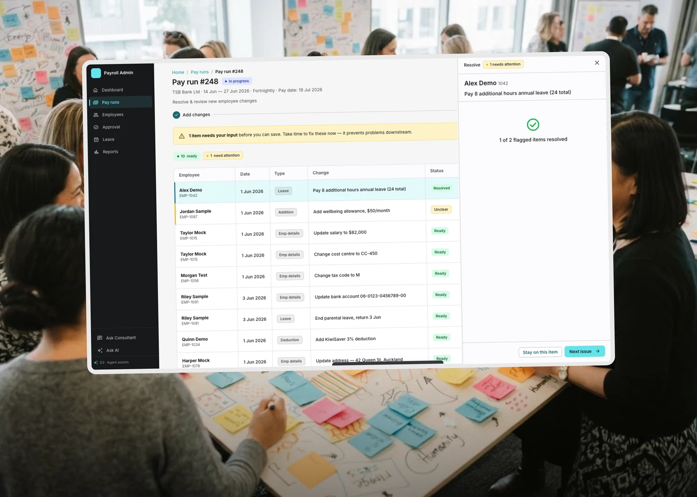 Datapay's Pay Run resolve screen, flagging items that need attention, floating over a workshop photo