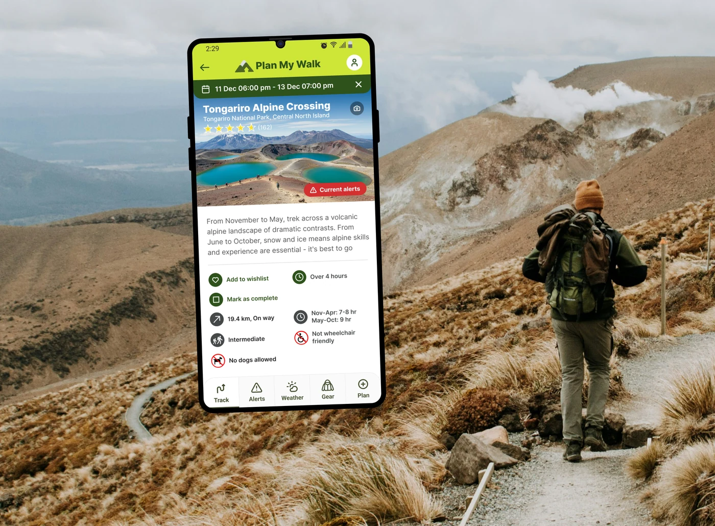 Plan My Walk app showing the Tongariro Alpine Crossing track screen, over a tramper on the trail